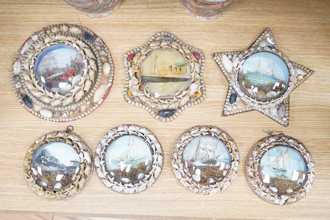 A collection of seven shellwork frames with convex glass, housing maritime interest prints with seaweed and shell decoration, largest 23cm in diameter